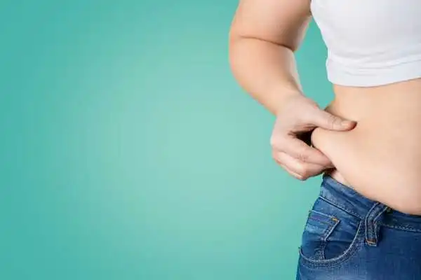 Image of woman pinching her love handles to show weight gain Cookham